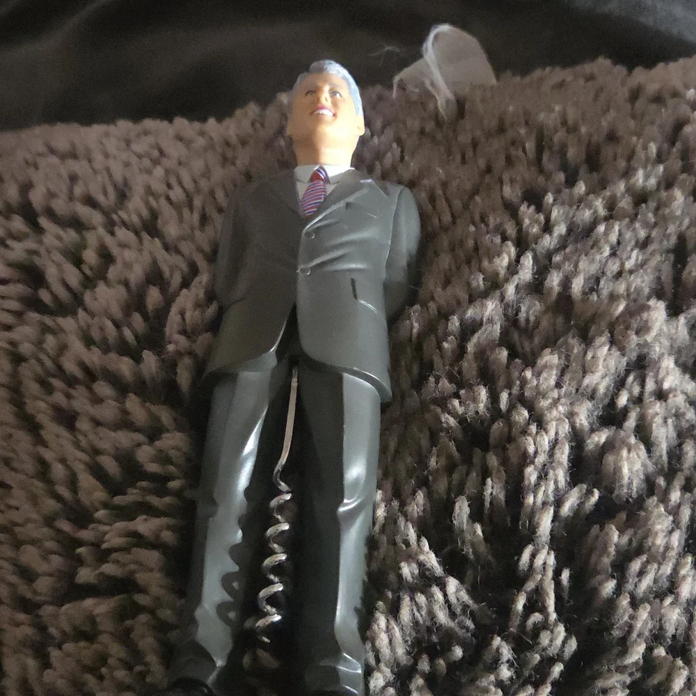 A novelty corkscrew wine opener shaped like a man in a suit / president-style